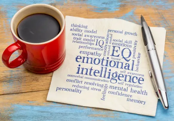 Coffee, pen, emotional intelligence words on napkin.