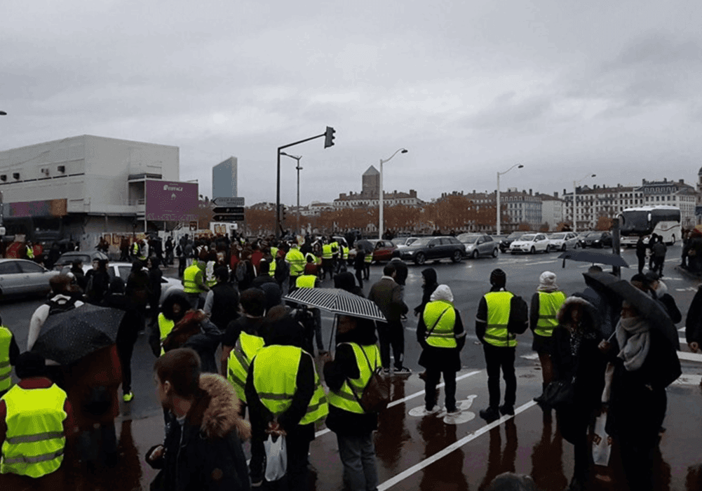 Protesters wearing yellow vests in urban area.