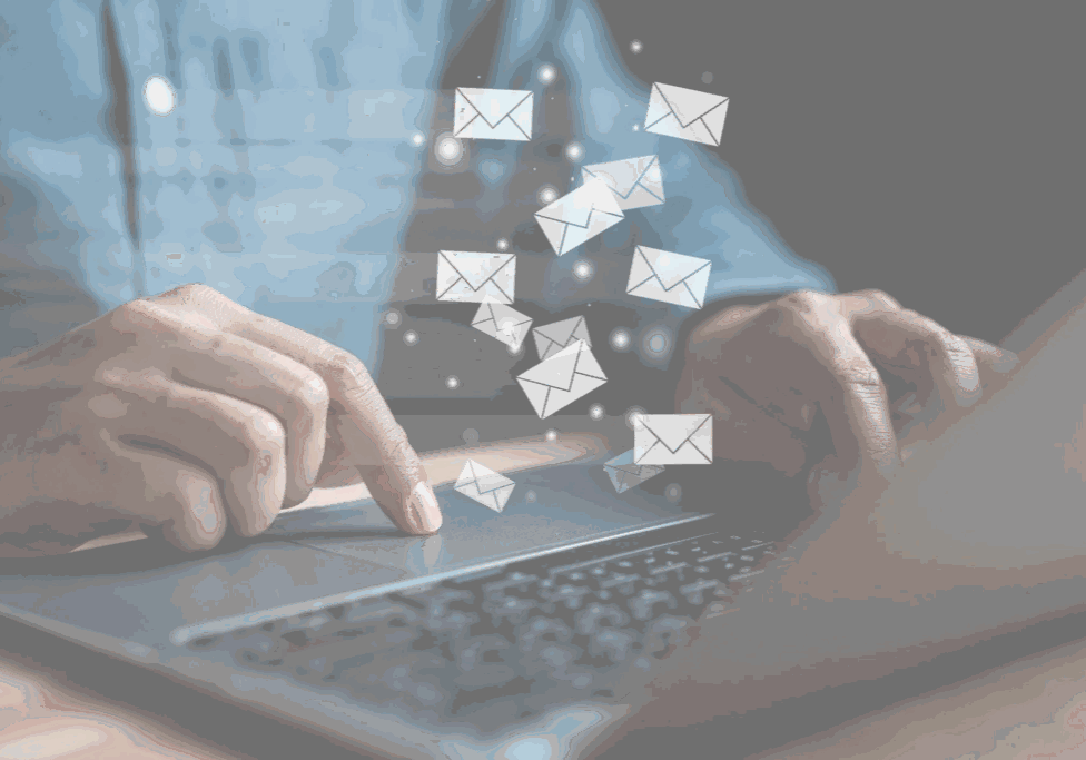 Person typing with floating email icons.