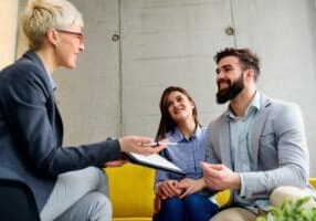 Professional meeting with a couple discussing documents.
