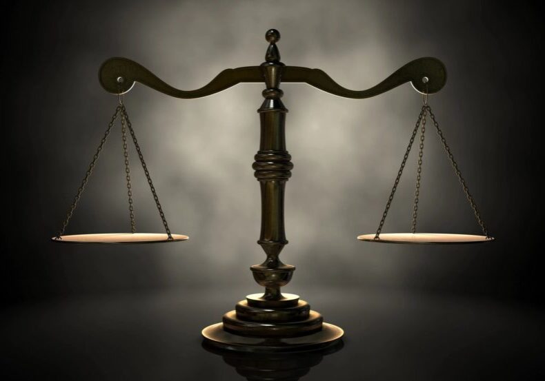 Bronze balance scale on a dark background.