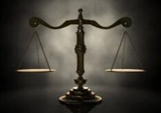 Bronze balance scale on a dark background.