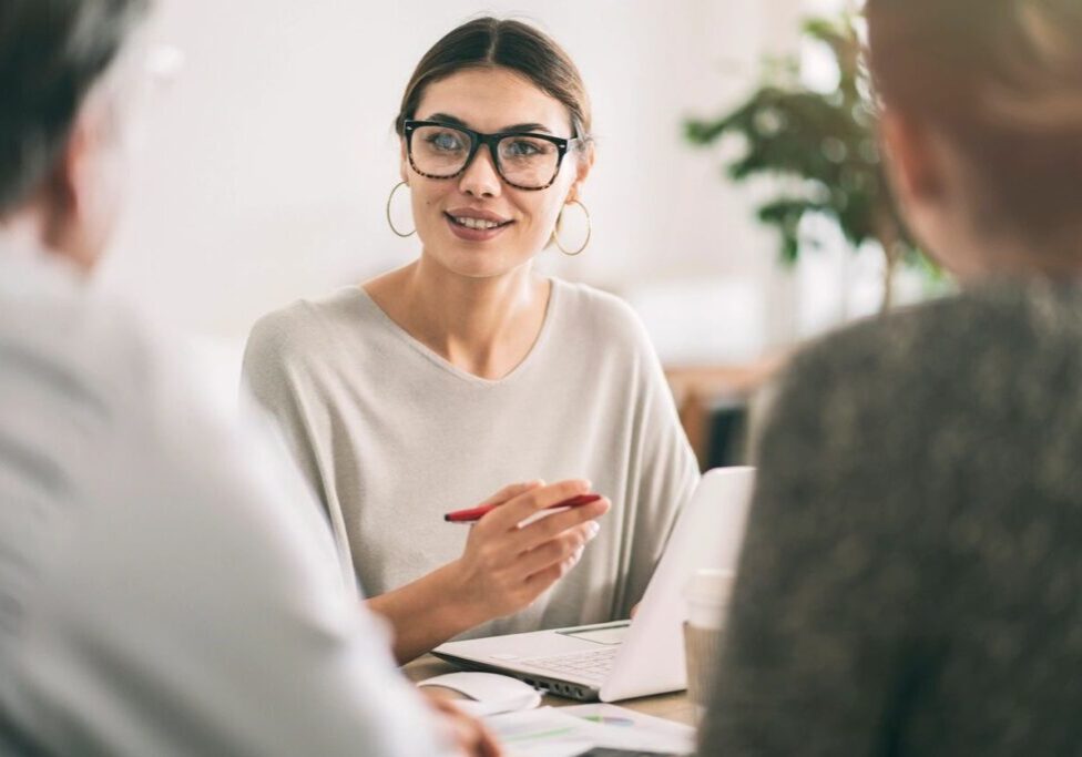 Business meeting with woman holding a pen.