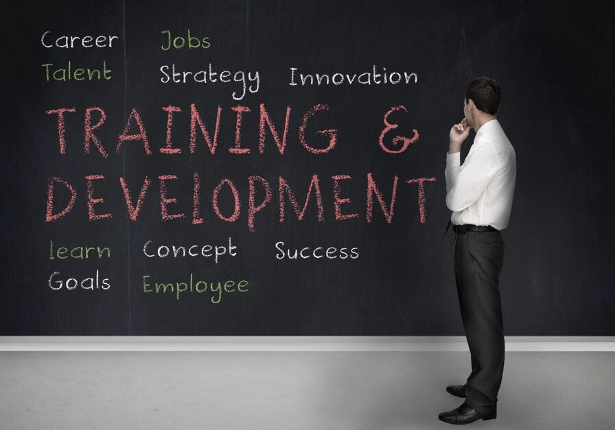 Man observing "Training & Development" on chalkboard.