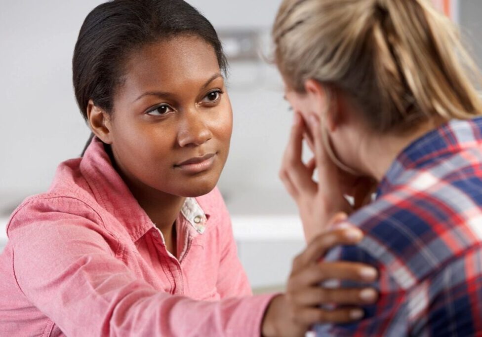 Woman comforting another woman in distress.