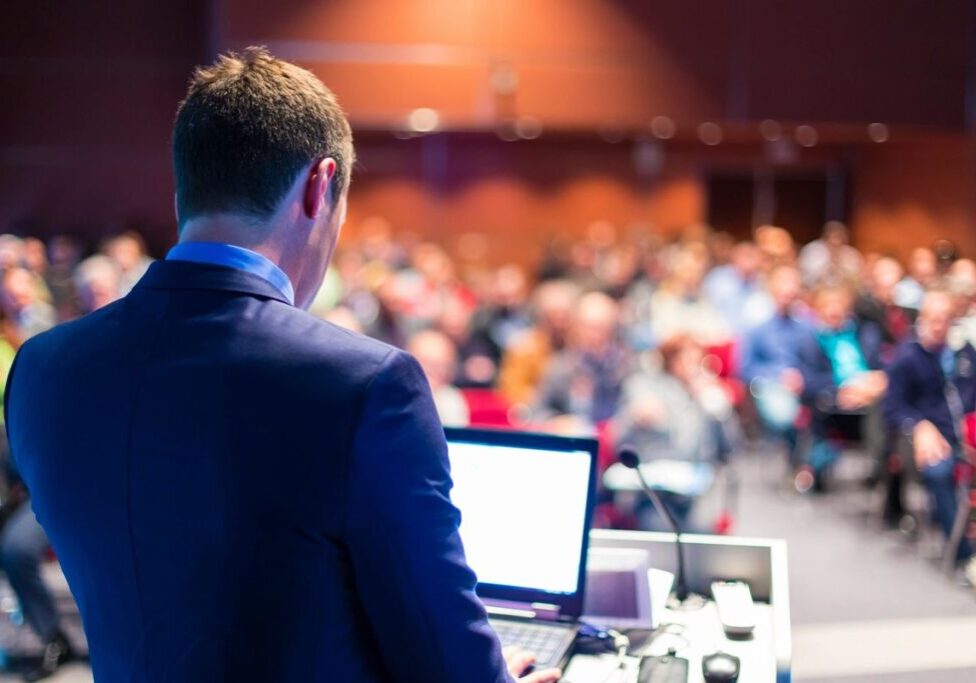 Speaker presenting to a large audience.