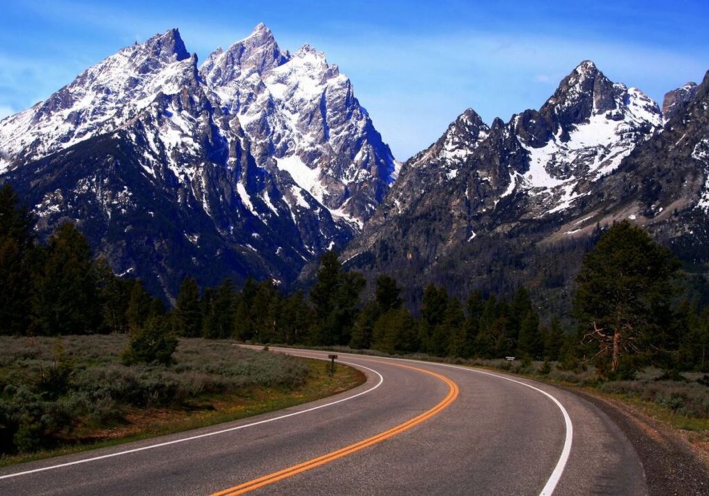 Winding road with snow-capped mountain view.